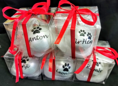 Weihnachtskugeln mit Hundepfote im Karton