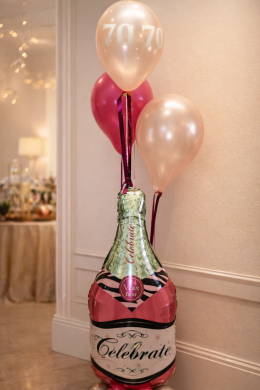 Pinke Sektflasche mit Ballons